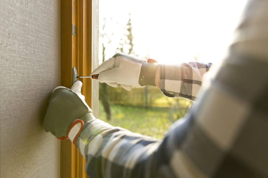 Technician repairing wood window hardware by hand