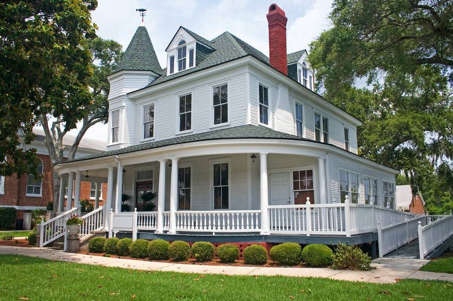 Historic Victorian home in the Boston area with a wraparound porch, turret, and original wood windows